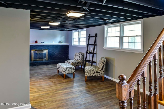 sitting room with hardwood / wood-style flooring and a brick fireplace