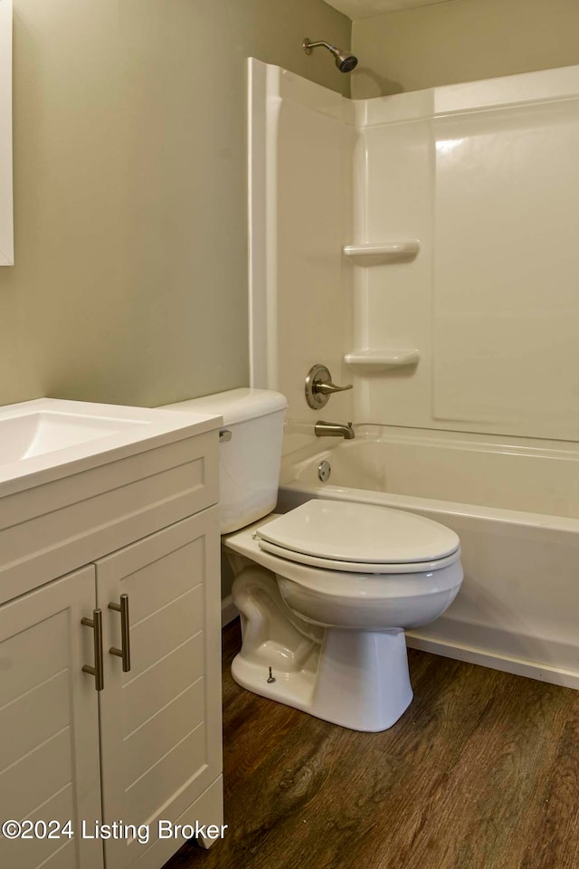 full bathroom with shower / bathing tub combination, hardwood / wood-style floors, vanity, and toilet