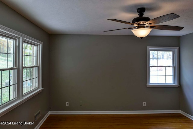 unfurnished room with ceiling fan, hardwood / wood-style flooring, plenty of natural light, and a textured ceiling