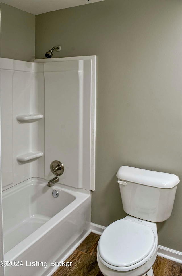 bathroom with hardwood / wood-style flooring, bathtub / shower combination, and toilet