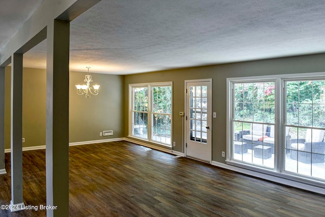 entryway with dark hardwood / wood-style floors, a notable chandelier, and a textured ceiling