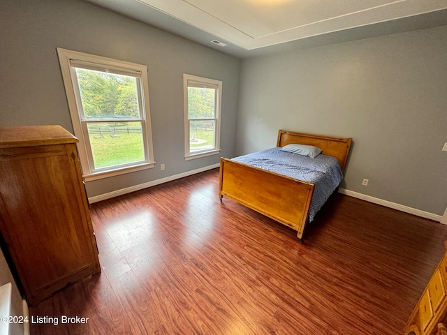 bedroom with dark hardwood / wood-style flooring