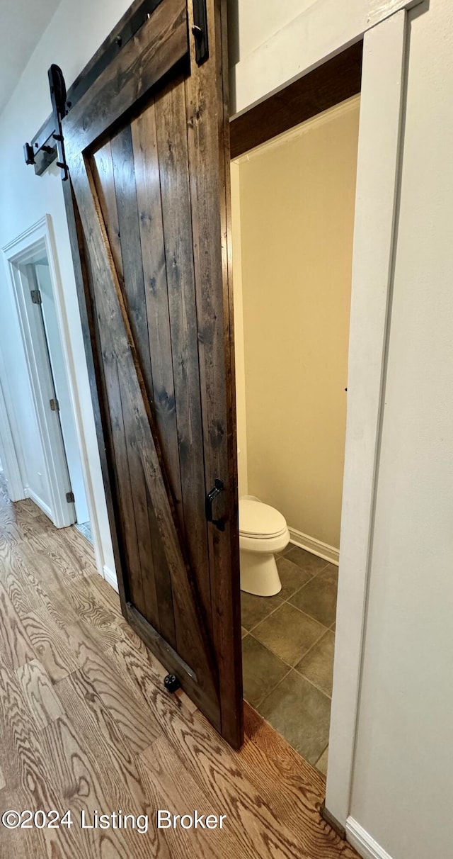 bathroom featuring wood-type flooring and toilet