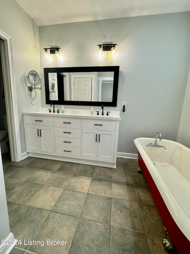 bathroom featuring toilet, vanity, and a bath