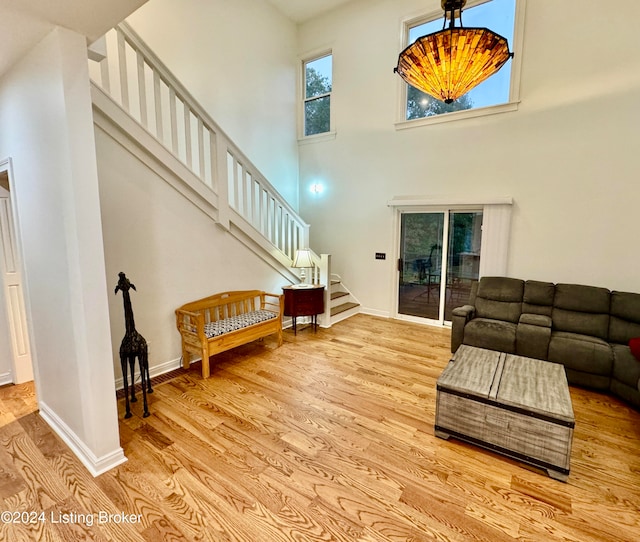 living room featuring a towering ceiling and light hardwood / wood-style flooring