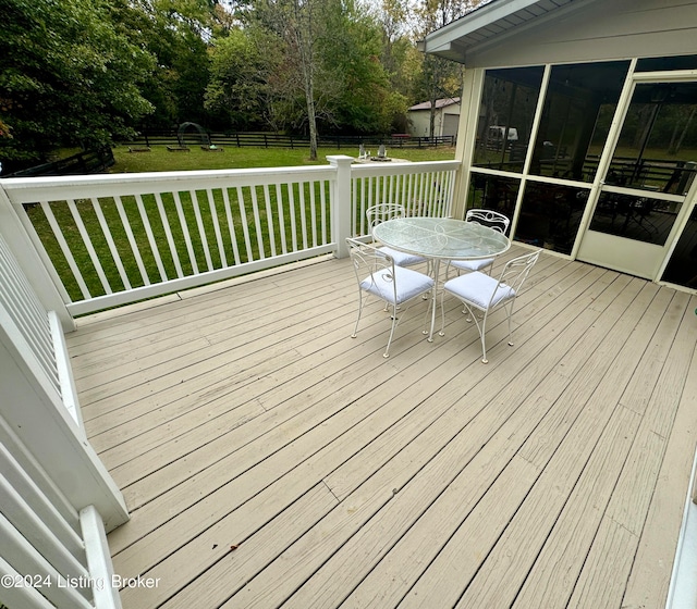 wooden terrace with a yard and a sunroom