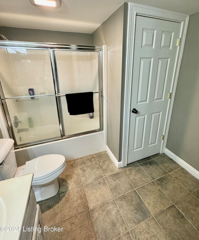 full bathroom featuring bath / shower combo with glass door, vanity, and toilet