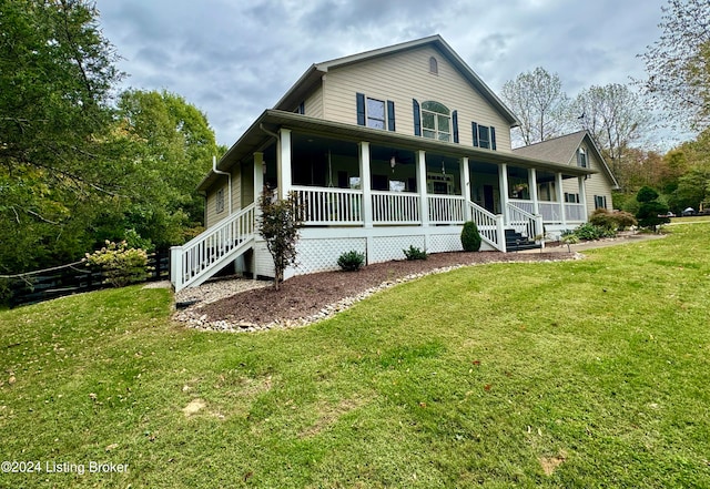 rear view of house featuring a porch and a yard