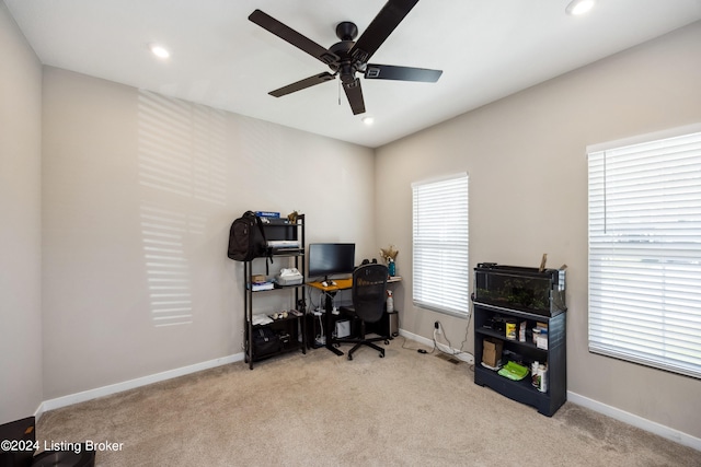 home office featuring light colored carpet, a wealth of natural light, and ceiling fan