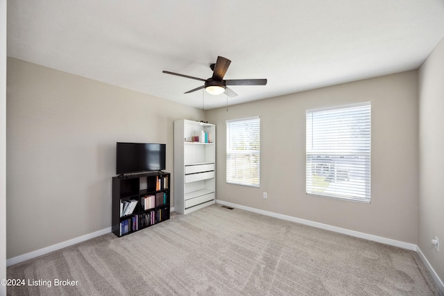 interior space with ceiling fan and light carpet