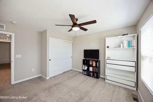 unfurnished bedroom with ceiling fan, a closet, and light colored carpet