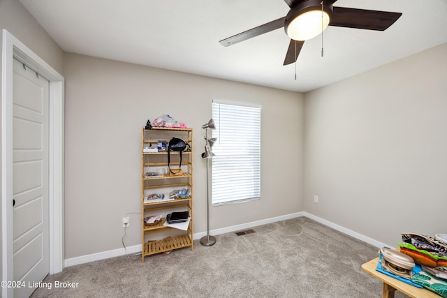 interior space with ceiling fan and light colored carpet