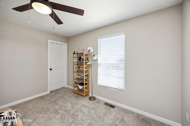 interior space featuring ceiling fan and light colored carpet