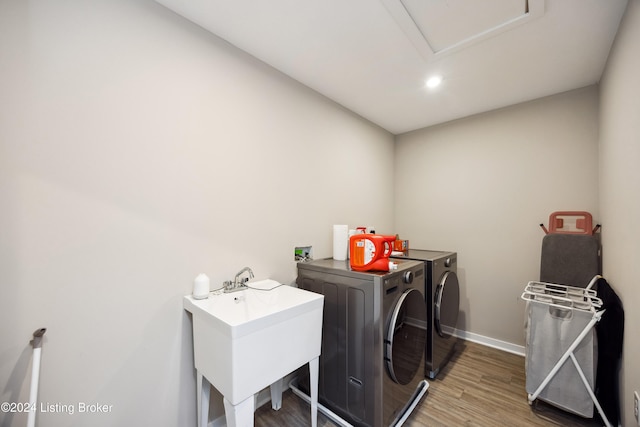 clothes washing area featuring independent washer and dryer, sink, and dark hardwood / wood-style floors