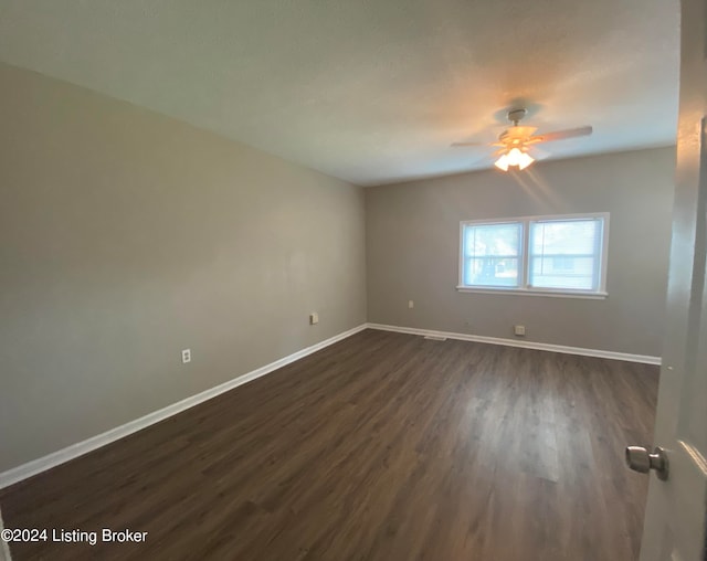 empty room with dark wood-type flooring and ceiling fan