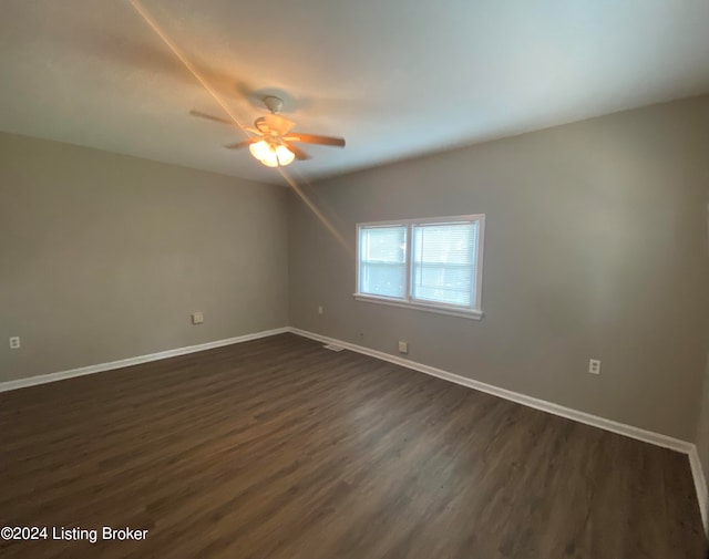 unfurnished room with ceiling fan and dark wood-type flooring