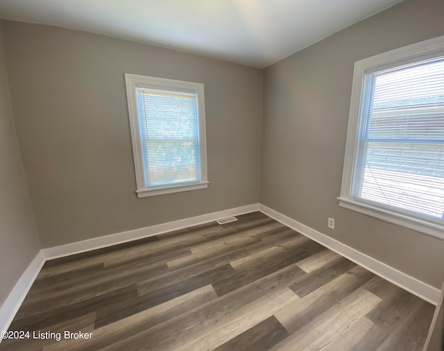 unfurnished room with a healthy amount of sunlight and dark hardwood / wood-style flooring