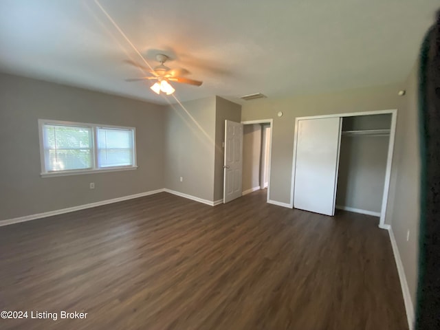 unfurnished bedroom with ceiling fan, a closet, and dark hardwood / wood-style floors