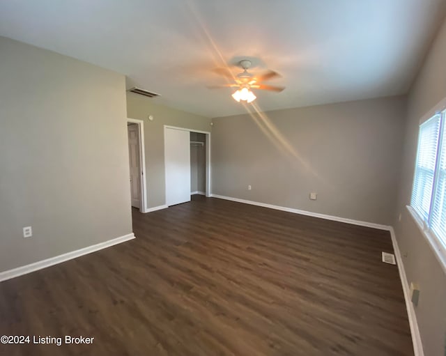 empty room with ceiling fan and dark hardwood / wood-style floors