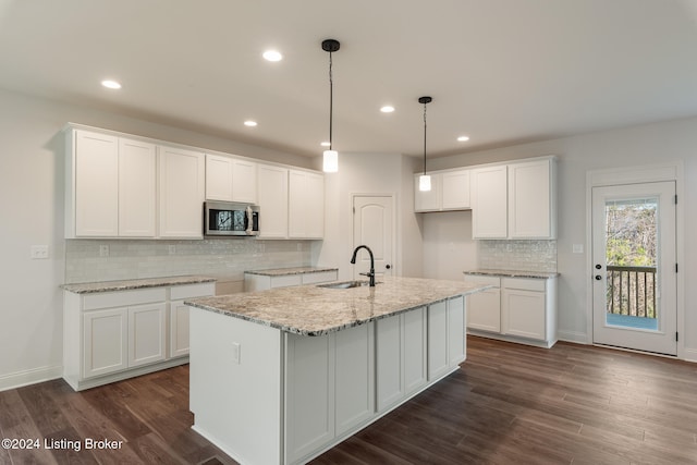 kitchen featuring white cabinets, dark hardwood / wood-style flooring, and a kitchen island with sink