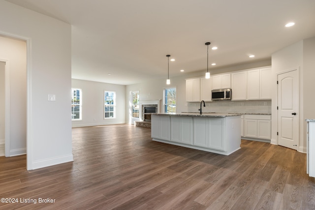 kitchen featuring white cabinets, dark hardwood / wood-style floors, and an island with sink