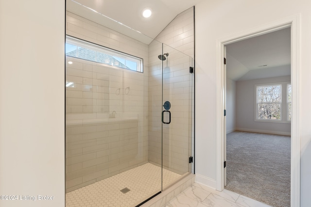 bathroom with walk in shower and lofted ceiling