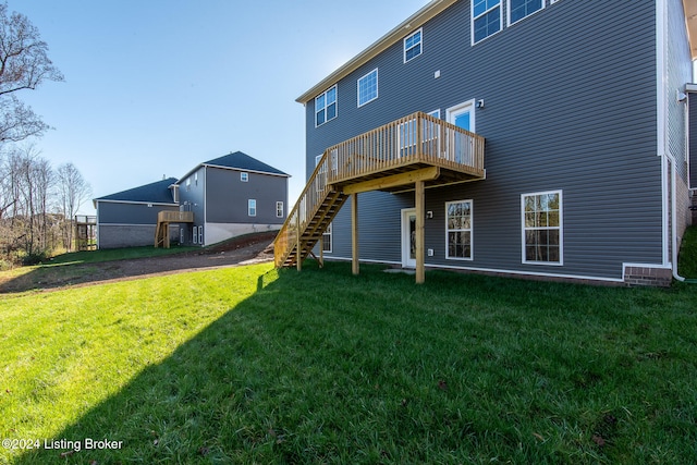 back of house with a wooden deck and a lawn