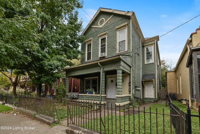 view of front of property featuring central AC unit, a front yard, and a porch