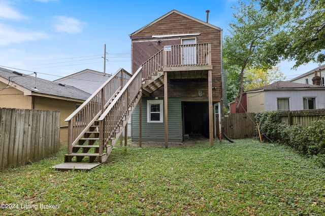 rear view of property featuring a lawn