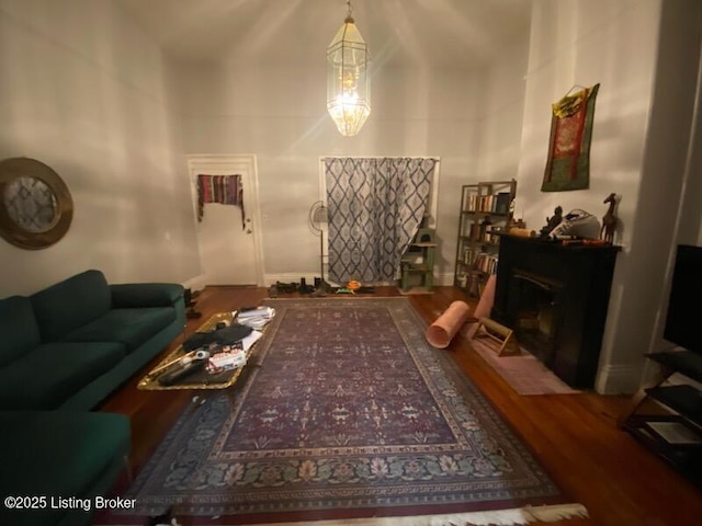 living room featuring hardwood / wood-style flooring, a fireplace, and a towering ceiling