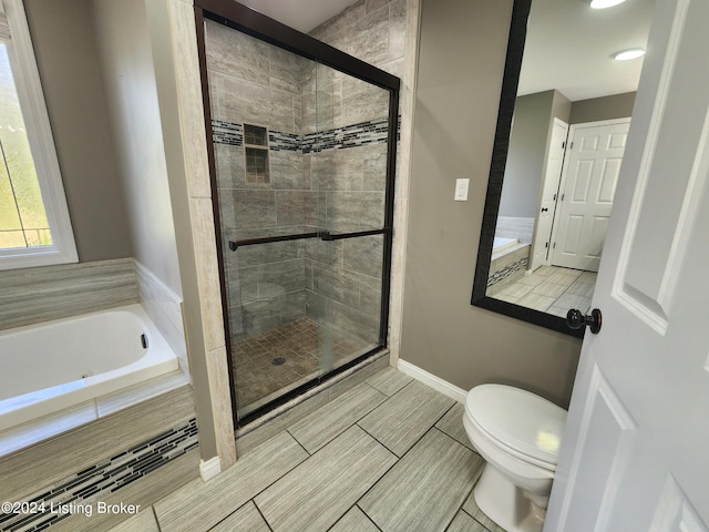 bathroom featuring shower with separate bathtub and toilet