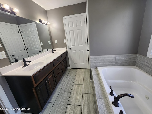 bathroom featuring a relaxing tiled tub and vanity