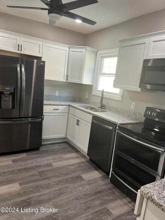 kitchen with appliances with stainless steel finishes, dark wood-type flooring, sink, and white cabinets