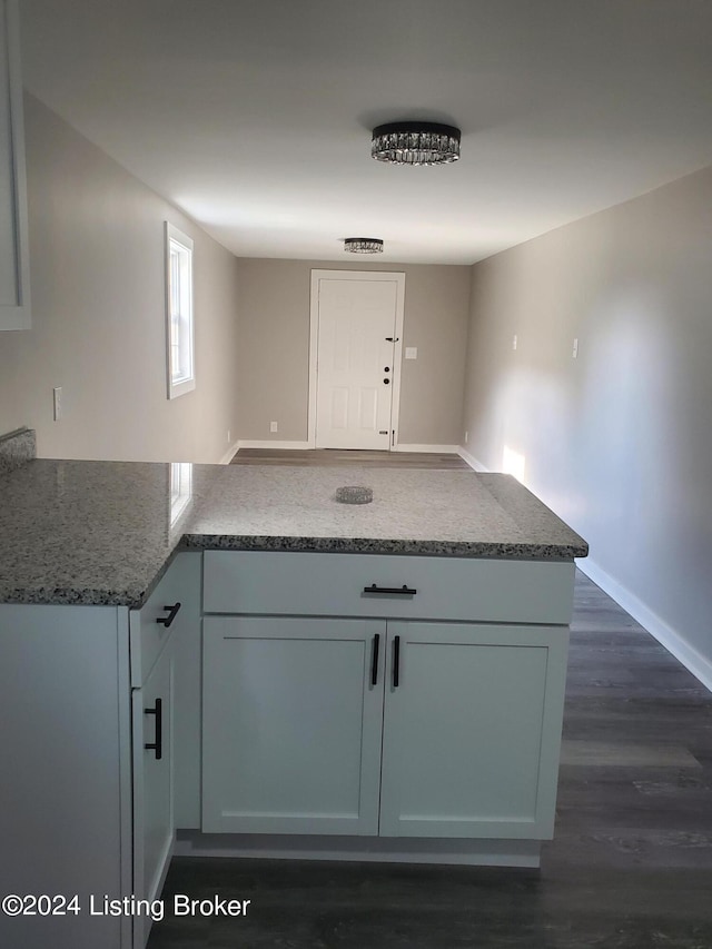 kitchen with kitchen peninsula and dark hardwood / wood-style floors