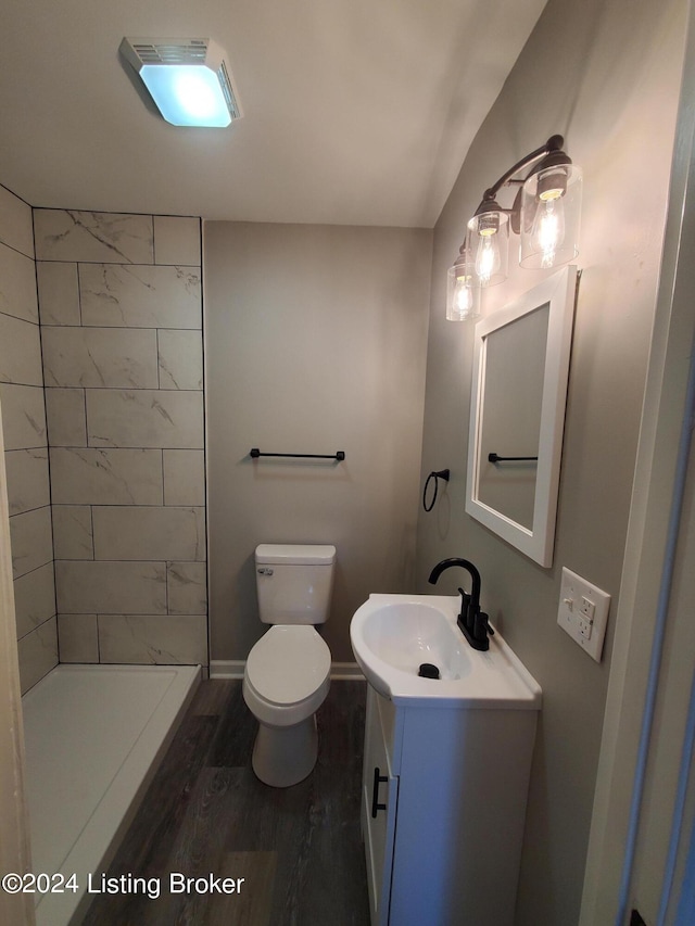 bathroom featuring vanity, a shower, hardwood / wood-style floors, and toilet