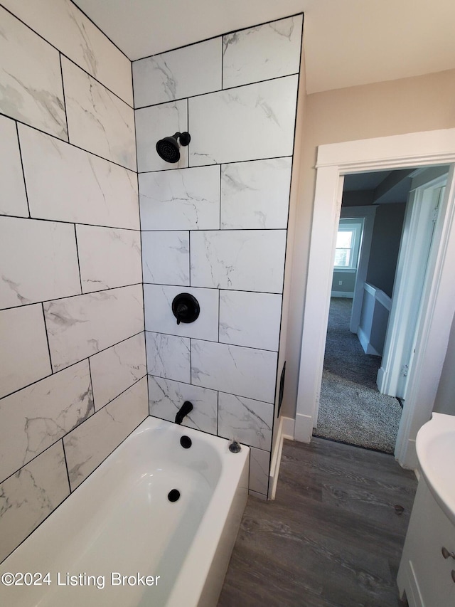 bathroom featuring vanity, hardwood / wood-style floors, and tiled shower / bath combo