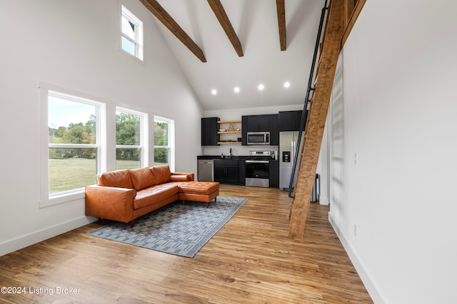 living room featuring light hardwood / wood-style floors, high vaulted ceiling, and beamed ceiling