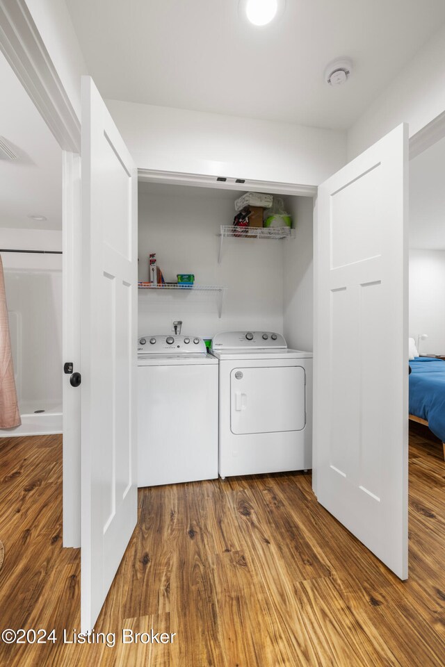 laundry area featuring washer and dryer and wood-type flooring