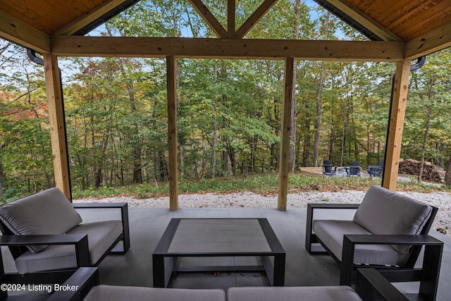 sunroom featuring wood ceiling, a wealth of natural light, and vaulted ceiling