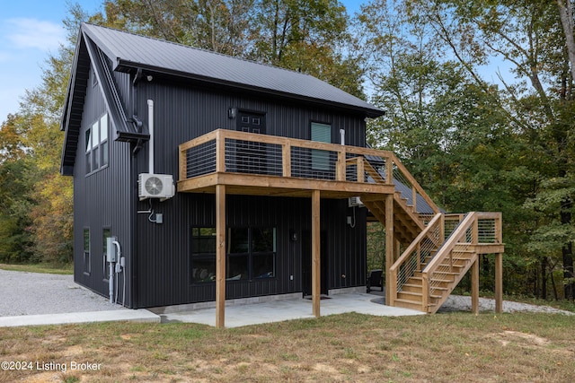 rear view of property with ac unit, a yard, a deck, and a patio area