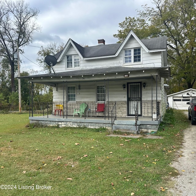 view of front of home with a front yard, covered porch, a garage, and an outdoor structure