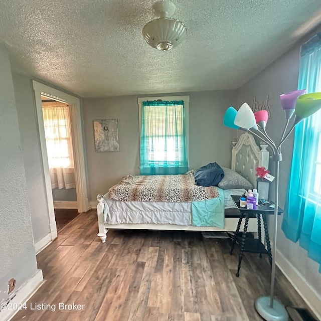 bedroom with wood-type flooring and a textured ceiling