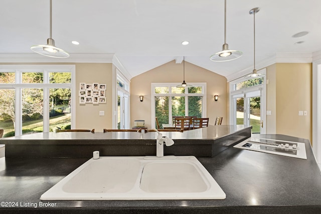 kitchen with lofted ceiling, decorative light fixtures, sink, and crown molding