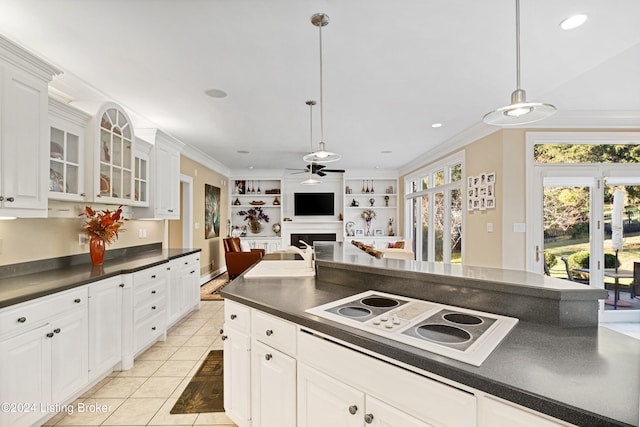 kitchen featuring white electric cooktop, decorative light fixtures, and white cabinets