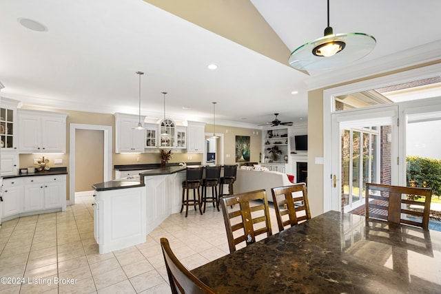 tiled dining space featuring ornamental molding, lofted ceiling, and ceiling fan