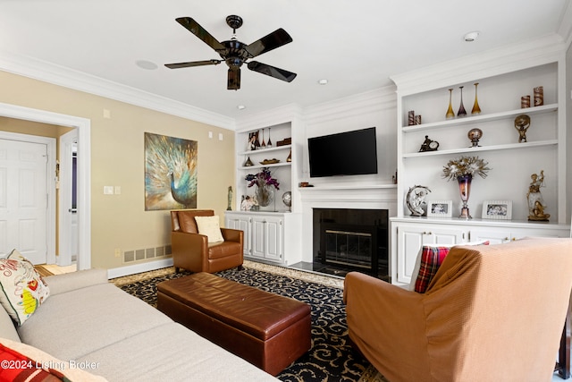 living room with crown molding, built in features, and ceiling fan