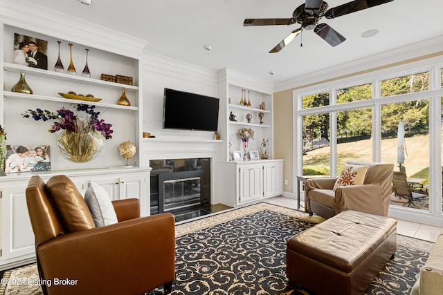 tiled living room with ornamental molding, built in features, and ceiling fan