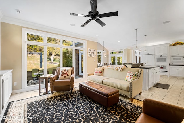 tiled living room with ceiling fan, ornamental molding, and sink