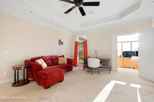 carpeted living room featuring crown molding, a tray ceiling, and ceiling fan