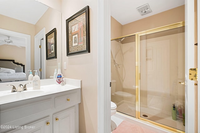 bathroom with vanity, ceiling fan, toilet, and walk in shower